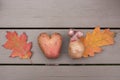 Non-standard potatoes in the shape of a heart and in the form of a funny ugly head and orange autumn leaves