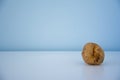 non-standard ugly fresh raw potato unusual form lying closely on light blue background.
