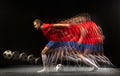 Non stop moving. Young caucasian football soccer player playing in motion in mixed light on dark background.