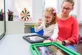 Non-verbal girl living with cerebral palsy, learning to use digital tablet device to communicate. Speech-generating devices.