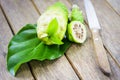 Noni fruit and noni slice on leaf and knife on wooden table.1 Royalty Free Stock Photo