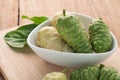 Noni Herbal Fruit on the Plate and wood floors.