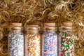 Nonpareils, colored tiny sugar balls, in glass bottles over angel hair