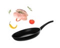 Nonstick frying pan with falling chicken fillet and vegetables on white background.