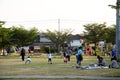 Asian thai family relax play with picnic and people jogging exercise at playground on yard in public garden park
