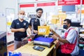 Nonthaburi, THAILAND - MAY 24, 2020 : Asian staff wearing mask working at the post office with customer at counter service