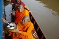 Thai people praying put food and thing offerings to monks procession on boat in tradition of almsgiving at Wat Sai Yai on November Royalty Free Stock Photo