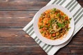 Noodle meat, sauce and herbs in a plate on a towel on a dark wooden background, Caucasian Asian cuisine Royalty Free Stock Photo