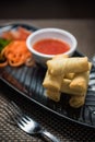 Noodle spring rolls with vegetable on black plate Royalty Free Stock Photo