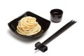 Noodles in black ceramic dish stand on white table background wi Royalty Free Stock Photo