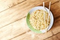 Noodles on the bowl with spoon and fork on wooden table background