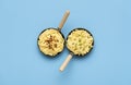 Noodles with cheese in small pans on a blue table, above view Royalty Free Stock Photo