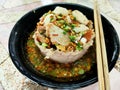 Noodles with Meatballs and pork with various seasonings placed in a black cup served with wooden chopsticks