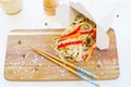 Noodles with mushroom and vegetables in take-out box on wooden table Royalty Free Stock Photo