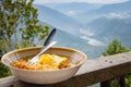 Noodles and omelette served in a bowl for breakfast. Photo taken with background of hills and river valley