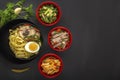 Noodles with pieces of meat and egg in a black plate and dim sum with different traditional snacks of mushrooms, soy Royalty Free Stock Photo