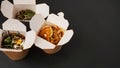 Noodles with pork and vegetables in take-out box on black table Royalty Free Stock Photo