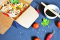 Noodles with pork and vegetables in take-out box on black table. Chinese noodles with vegetables. Ingredients in box Royalty Free Stock Photo