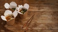 Noodles with pork and vegetables in take-out box on wooden table Royalty Free Stock Photo