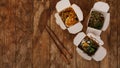 Noodles with pork and vegetables in take-out box on wooden table Royalty Free Stock Photo