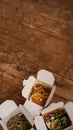 Noodles with pork and vegetables in take-out box on wooden table Royalty Free Stock Photo