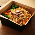 Noodles with pork and vegetables in take-out box on wooden table Royalty Free Stock Photo