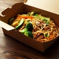 Noodles with pork and vegetables in take-out box on wooden table Royalty Free Stock Photo