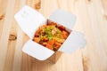 Noodles with salmon, onion and bell pepper in take away box