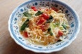 Simple noodle soup with the addition of tomatoes and mustard greens and a sprinkling of chili powder and fried shallots.