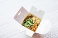 Noodles in a white box on a wooden background close up shot Royalty Free Stock Photo