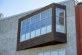 Nook on house or building exterior with wooden panneling and cement facade with visible windows and back yard trees in Royalty Free Stock Photo