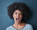 Nooooo. Studio portrait of an attractive young woman screaming against a blue background. Royalty Free Stock Photo