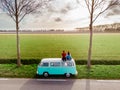 Noordoostpolder Netherlands April 2019, Classic Green and white VW Camper Van parked with couple watching the Sunrise