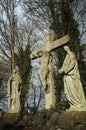 .Damaged concrete statues of Jezus on a cross with Mary and Joseph next to him