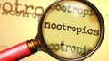 Nootropics and a magnifying glass on English word Nootropics to symbolize studying, examining or searching for an explanation and