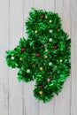 Nop view of Abstract Christmas Tree Made of green tinsel with red and gold balls on white wooden floor Royalty Free Stock Photo
