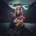 Nordic goddess in ritual garment with hawk near wild mountain lake in Innerdalen valley.