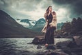 Nordic goddess in ritual garment near wild mountain lake in Innerdalen valley.