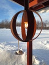 Nordic style lighted lamp in snowy lapland landscape with snow shovel. Swedish lighting at shelter entrance