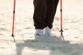 Nordic walking. Female legs hiking on the beach. Royalty Free Stock Photo