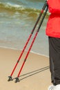 Nordic walking. Female legs hiking on the beach. Royalty Free Stock Photo