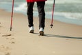 Nordic walking. Female legs hiking on the beach. Royalty Free Stock Photo