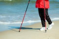 Nordic walking. Female legs hiking on the beach. Royalty Free Stock Photo