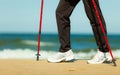 Nordic walking. Female legs hiking on the beach. Royalty Free Stock Photo