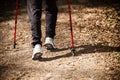 Nordic walking. Female legs hiking in forest or park. Royalty Free Stock Photo