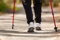 Nordic walking. Female legs hiking in the park. Royalty Free Stock Photo