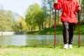 Nordic walking. Female legs hiking in the park. Royalty Free Stock Photo