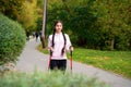 Nordic walking with pretty Indian woman walking with Scandinavian sticks in the park