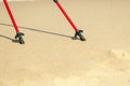 Nordic walking. Red sticks on the sandy beach Royalty Free Stock Photo