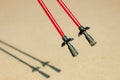 Nordic walking. Red sticks on the sandy beach Royalty Free Stock Photo